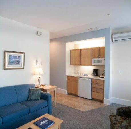 Room with kitchen and soft sofas, large windows, table in Beachmere West