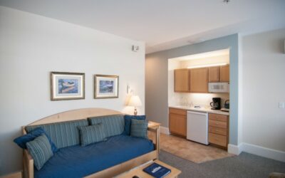 Room with kitchen and soft sofas, large windows, table in Beachmere West