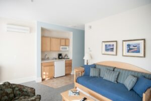 Room with kitchen and soft sofas, large windows, table in Beachmere West