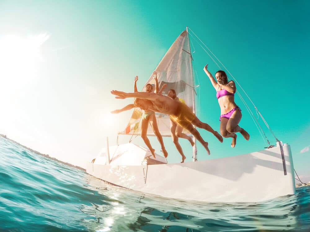 Photo of a Group of Friends Jumping into the Atlantic Ocean from a Boat. Boating Remains One of the Best Things to Do in Ogunquit, ME.