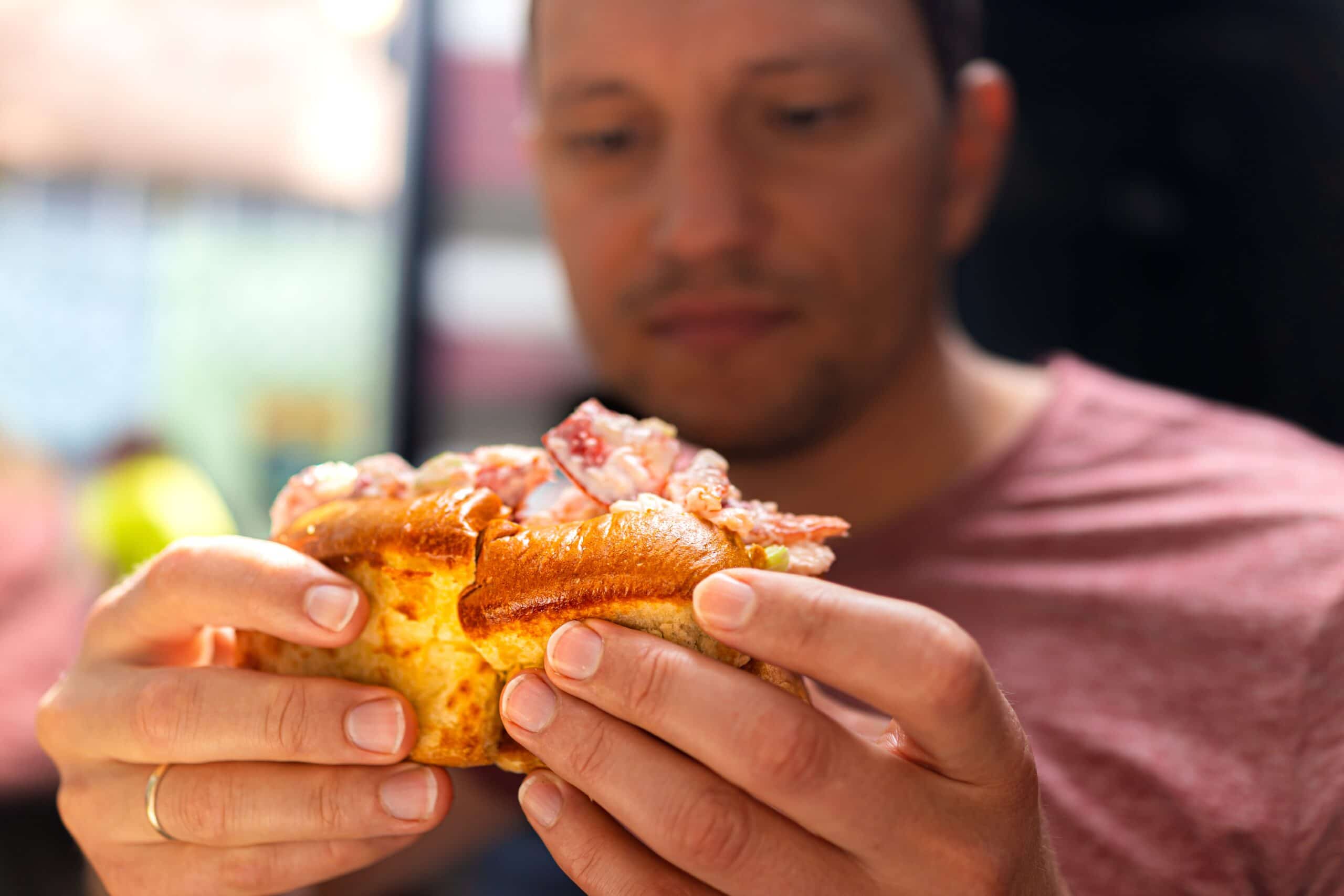 A man eating the best lobster roll in Ogunquit, Maine.