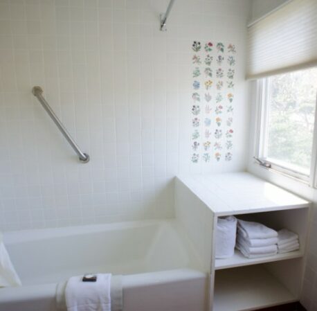 White bathroom with bathtub and window views in Mayfair
